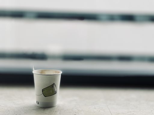 A selective focus shot of a plastic coffee cup on a blurred background
