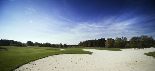 A beautiful scenery at a sandy portion of a golf course under a clear blue sky background