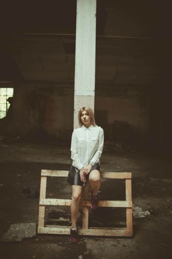 A young Caucasian female from Bosnia and Herzegovina posing at camera in the abandoned place