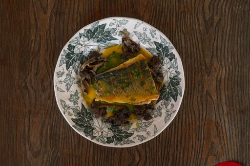An overhead shot of a savory fish dish on a wooden table