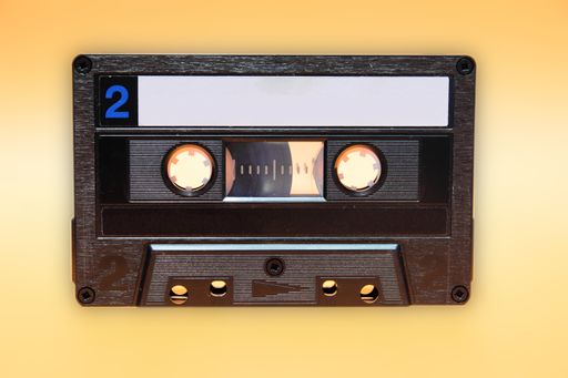 Retro audio cassette tape on yellow background. Front view of side two and traces of dust with minor scratches
