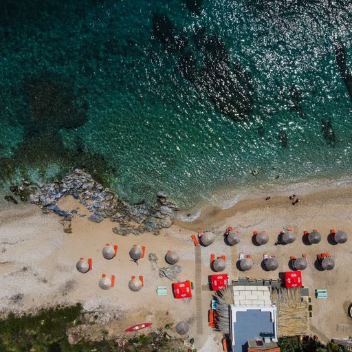 An aerial photo of the small beach with orange folding chairs, in the afternoon