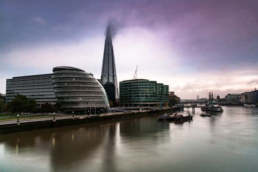 A panoramic shot of the London city hall with the Shard behind along the River Thames at dawn