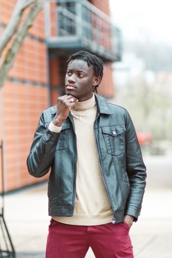 A vertical shot of a young stylish Afro-American guy in the streets of Lyon in France