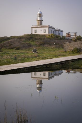 A view and reflection of the Punta Insua or Larino lighthouse in Carnota, Galicia, Spain