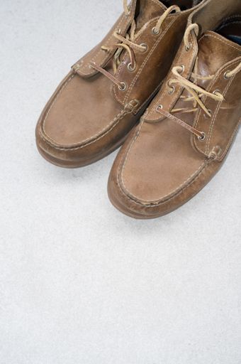 A vertical shot of comfortable brown shoes on a gray surface