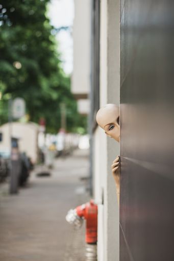 A vertical shot of a naked female mannequin near a black wall