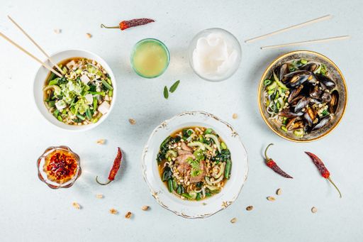A top view of various healthy delicious food in bowls on a white surface