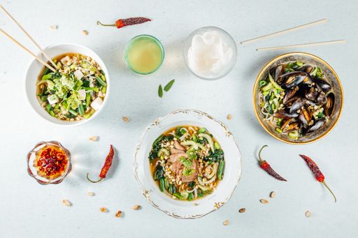 A top view of various healthy delicious food in bowls on a white surface