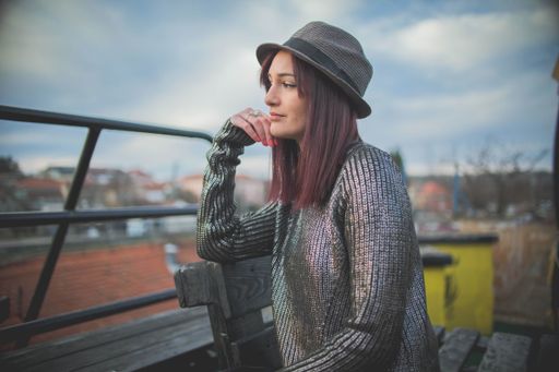 An attractive Caucasian female in a hat posing for the camera outdoor