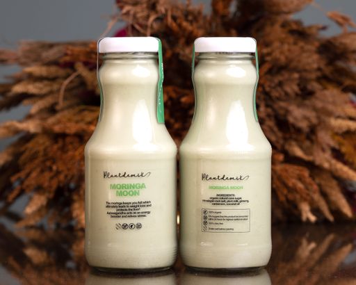 A closeup shot of vegan milks in a glass bottle on the table