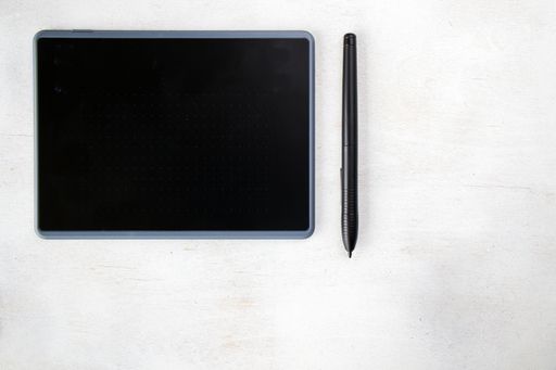 A top view of drawing tablet with pen on the white background