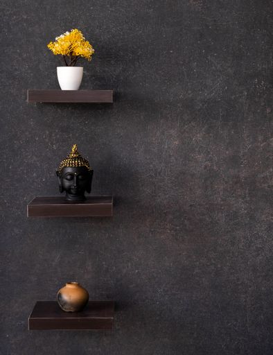 Three decorative shelves with potted flowers, the head of Buddha and a flower vase