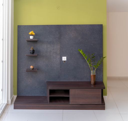 A TV stand with shelves houseplant and decors in the living roo