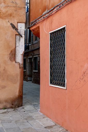 A narrow street between the buildings in Venice, Italy