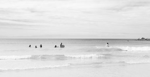 Cape Town, South Africa - March 13 2019: Kids Swimming on Fish Hoek beach on a cloudy day
