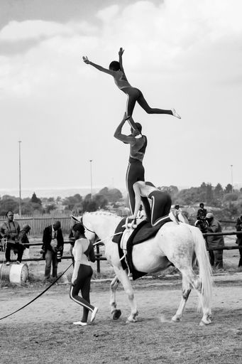 Soweto, South Africa - April 16, 2012: Young African children performing acrobatics on horse back