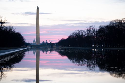 A beautiful sunrise of the Washington Monument reflected in the pool and the U.S.Capitol in the background