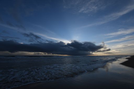 A scenic view at a sandy beach during sunset