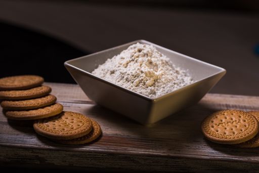 A closeup shot of tasty cookies with flour on a rusty surface on a black background