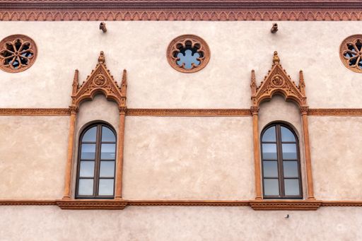 A closeup shot of the former Benedictine Monastery's arched and round window frames in Tuscany, Italy