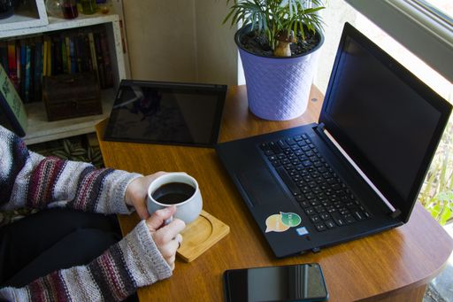A female typing on a laptop, working in an office