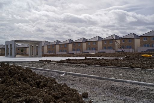 Construction site with row of newly built identical detached houses. It's the part of the Glenveagh Marina Village development in Greystones, Ireland.