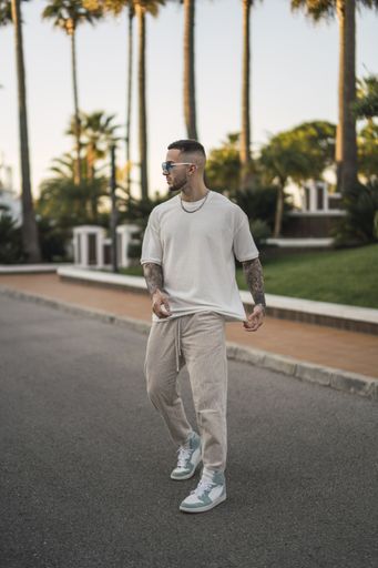 A vertical shot of a tattooed stylish man standing outside
