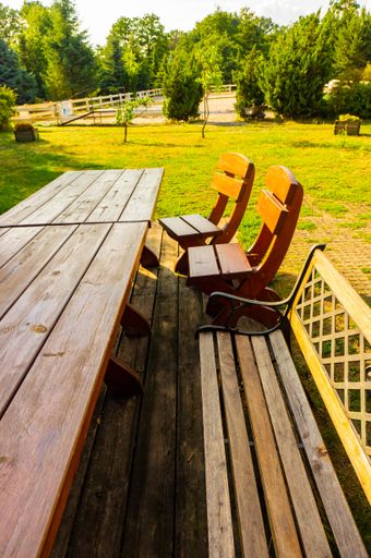 A beautiful view of a wooden bench and table in the park on a sunny day