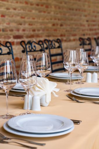 A vertical shot of a festive table setting with empty wine glasses and white plates