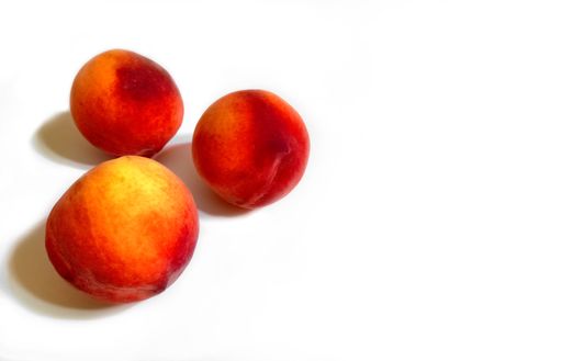 High angle shot of delicious fresh juicy sweet ripe peaches on a white background. Fruit used in jams, desserts, salads and smoothies. Copyspace