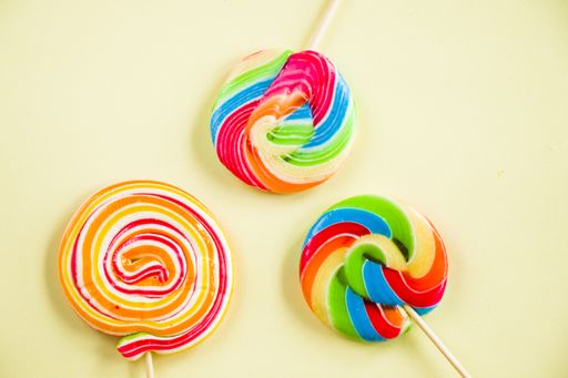 A top view of three twisted lollypops on the light background