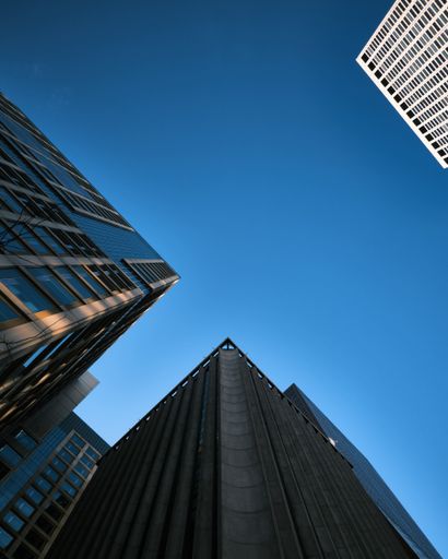 A  vertical shot of modern skyscraper facades against a clear blue sky