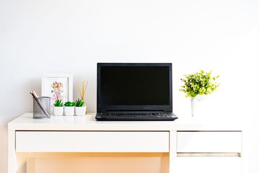 A laptop on a white desk, working from home, the new normal