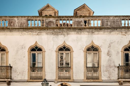 An old building with a weathered white facade in Lagos, Algarve, Portugal