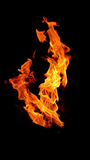 A vertical shot of burning fire on dark background