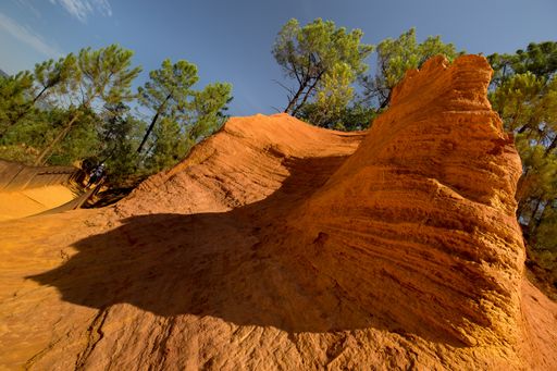 A closeup of canyons surrounded by greenery under the sunlight and a blue sky