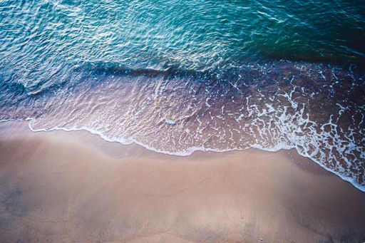 A high angle shot of the sandy shore of the sea with turquoise water - perfect for a wallpaper