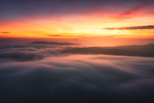 A closeup shot of clouds under an orange sunset sky