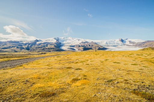 A mesmerizing view of the rocky and snowy mountains under the cloudy blue sky in Iceland
