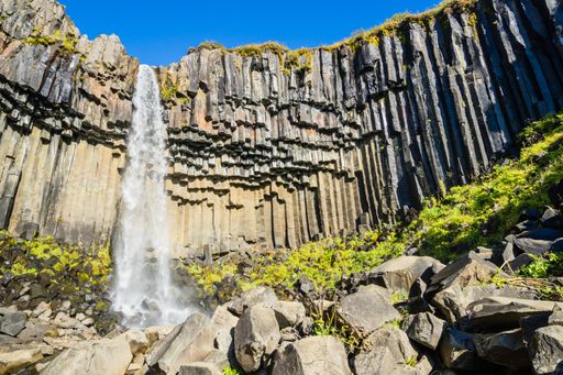 A mesmerizing view of the beautiful Svartifoss waterfall streaming down the rocky mountain in Iceland