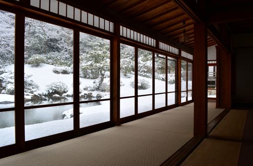 Stunning Japanese winter garden viewed from inside traditional room with panorama windows.