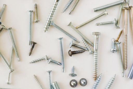 A top view of different sizes of screws and bolts isolated on the white background