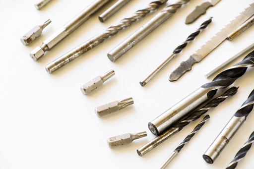 A closeup shot of different sizes of drill bits and screws isolated on white background