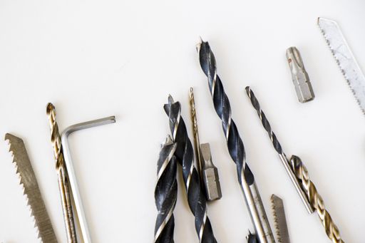 A closeup shot of different sizes of drill bits and screws isolated on white background