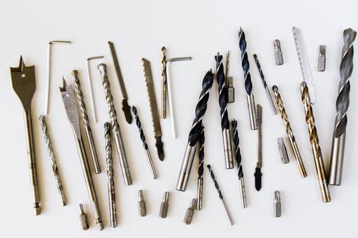 A closeup shot of different sizes of drill bits and screws isolated on white background