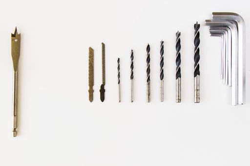 A top view of different drill bits and tools heads set and kit on the white background