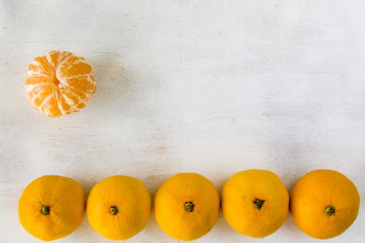 A top view of fresh peeled and whole clementine isolated on a white  surface