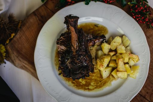A top view of a plate of a hot delicious baked rack of lamb and potatoes