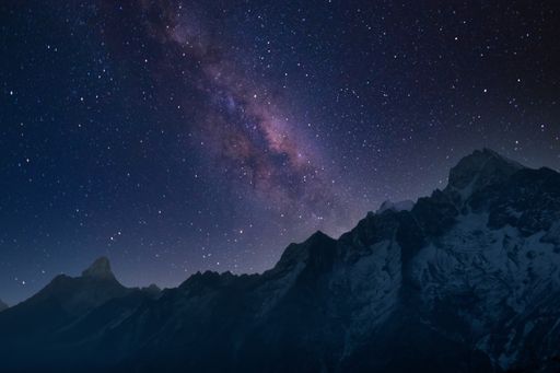 A beautiful shot of mountains under a starry sky at night